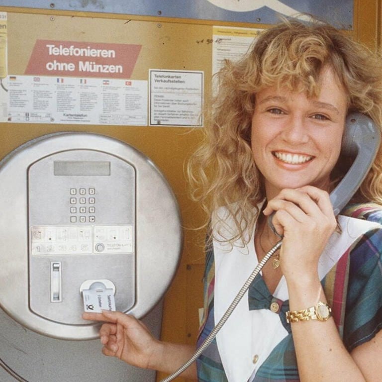 Eine Frau telefoniert in einer Tezefonzelle mit einer Telefonkarte: Das Kartentelefon galt 1987 als technische Revolution, ermöglichte es doch das Telefonieren ohne Münzen