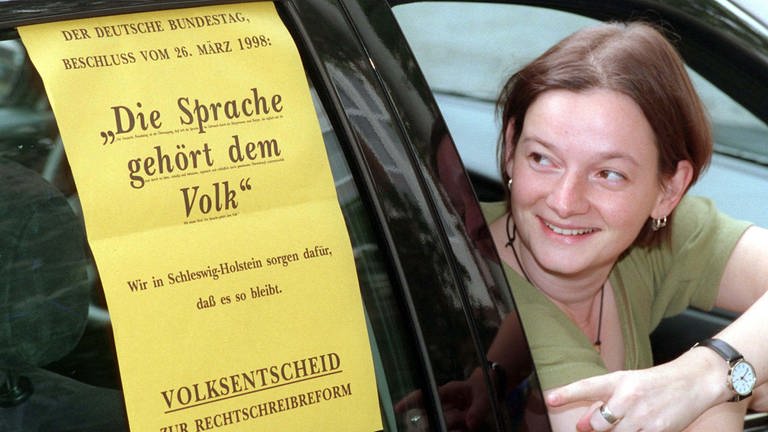 Stephanie Barrenberg begutachtet am 18. September 1998 das Plakat zum Volksentscheid der Rechtschreibreform. Die Gegner der Rechtschreibreform in Deutschland schauten am 27. September 1998 nach Schleswig-Holstein. Im nördlichsten Bundesland starteten sie den letzten Versuch, um das Einführen der neuen Schreibregeln noch zu verhindern.