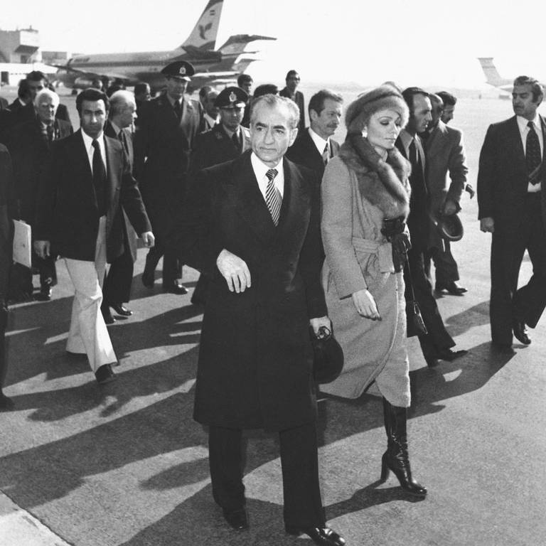 Schah Mohammad Reza Pahlavi und Kaiserin Farah gehen am 16.1.1979 über das Rollfeld des Mehrabad Airport zu einem Flugzeug, um das Land zu verlassen. Der Schah verließ im Zuge der islamischen Revolution von seinen Thron. (Foto: dpa Bildfunk, picture alliance/dpa | Uncredited)