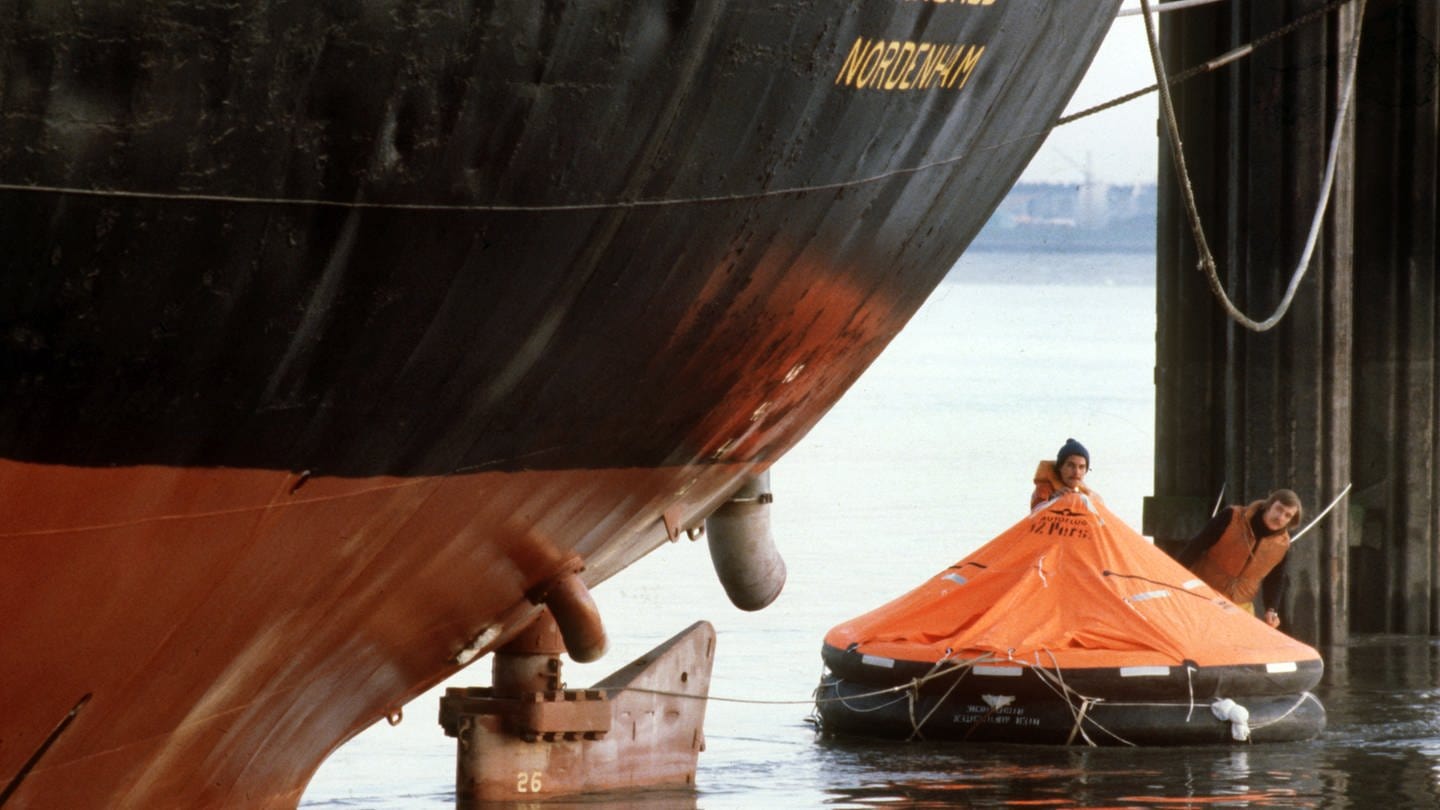 Mitglieder der Umweltschutzorganisation Greenpeace schwimmen am 13.10.1980 in einer roten Rettungsinsel vor dem Bug des Abfalltankers 