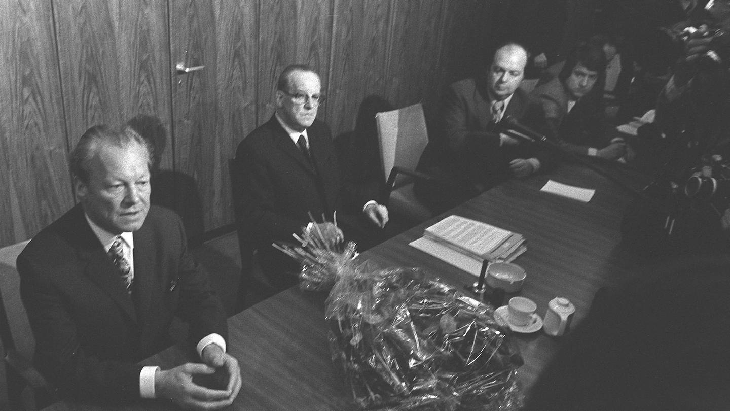 Willy Brandt (SPD, links) sitzt am 7. Mai 1974 am Tisch im Fraktionssaal, neben ihm Herbert Wehner. Auf dem Tisch ein Blumenstrauß. Am Vorabend hatte er beim Bundespräsidenten Gustav Heinemann seinen Rücktritt als Bundeskanzler eingereicht. (Foto: picture-alliance / Reportdienste, picture-alliance / Sven Simon | SVEN SIMON)