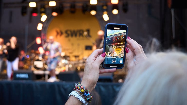 Frau hält Smartphone zur Aufnahme des SWR1 Auftritts (Foto: SWR, Markus Kuhn)