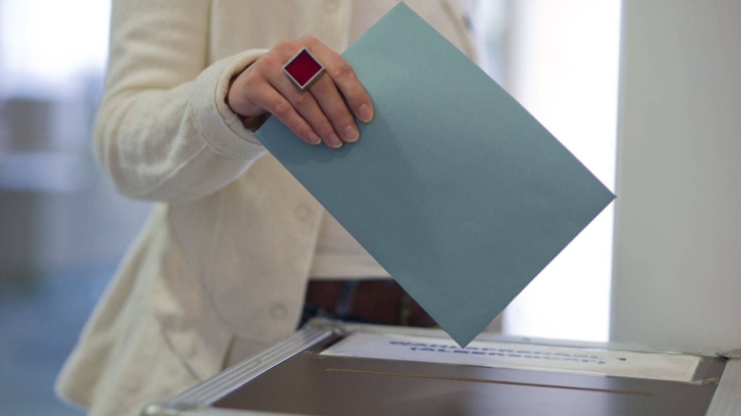 Frau wirft Stimmzettel in Wahlurne (Foto: IMAGO, IMAGO / blickwinkel)