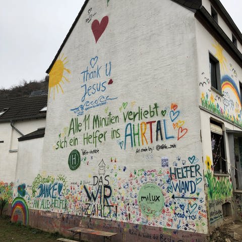 Auf eine Hauswand im Ahrtal stehen Botschaften an Helferinnen und Helfer (Foto: SWR)