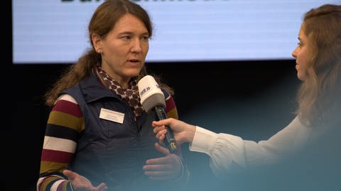 Eine Frau wird von einer Moderatorin mit einem SWR-Mikrofron interviewt (Foto: SWR)