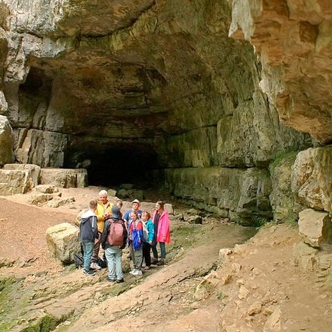 Die Gruppe steht vor dem Eingang zur Falkensteiner Wasserhöhle (Foto: SWR, SEO Entertainment)