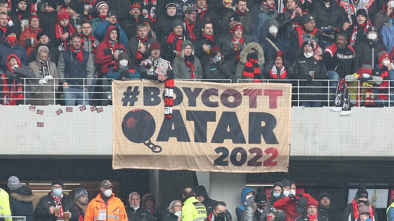 Menschen auf einer Fußballtribüne, am Geländer ein Transparent, auf dem "Boykott Qatar 2022" steht. (Foto: dpa Bildfunk, Picture Alliance)