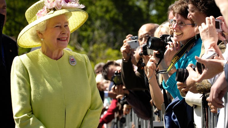 Königin Elisabeth die Zweite in einem gelben Kleid vor Publikum. (Foto: SWR, LOOKSfilm)