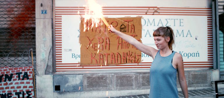 „#widerstand“: Helene zündet am Ende der Demo in Athen, gegen die geplante Räumung der besetzten Häuser, ein Bengalo an. © SWREikon Media (Foto: SWR, Eikon Media)