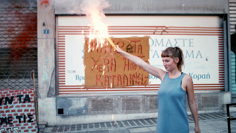„#widerstand“: Helene zündet am Ende der Demo in Athen, gegen die geplante Räumung der besetzten Häuser, ein Bengalo an. © SWREikon Media (Foto: SWR, Eikon Media)