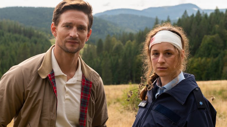 Ortspolizistin Tanja (Lou Strenger) und Fabian (August Wittgenstein), der neue Landarzt in Höllgrund. Im Hintergrund der Schwarzwald. (Foto: SWR, Studio Zentral/Maria Wiesler)