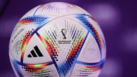 Das Bild zeigt den Ball der FIFA Fußball-WM 2022 in Katar. Er kombiniert die Hauptfarbe Weiß mit einem modernen Multicolor-Design. (Foto: dpa Bildfunk, SWR, Picture Alliance)