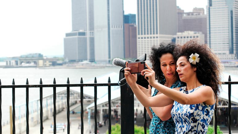 Nahid und Masih stehn vor Hochhäusern und machen Selfies (Foto: SWR, RealReal Doc AB)