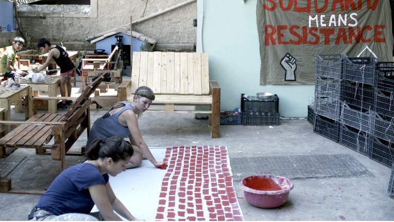 „#widerstand“: Helene malt zusammen mit einer anderen Aktivistin eine symbolische Mauer im Hinterhof vom City Plaza Hotel in Athen. © SWREikon Media (Foto: SWR, Eikon Media)