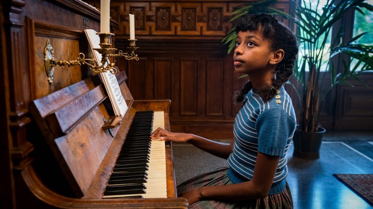 Eunice (Mahlet Paulke) sitz vor einem Klavier (Foto: SWR, Steffen Junghans)