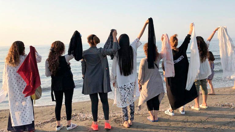 Iranerinnen legen ihren Hijab ab und protestieren so gegen die Pflicht, sich zu verschleiern. Die Frauen halte alle Ihre Kopftücher in der Hand