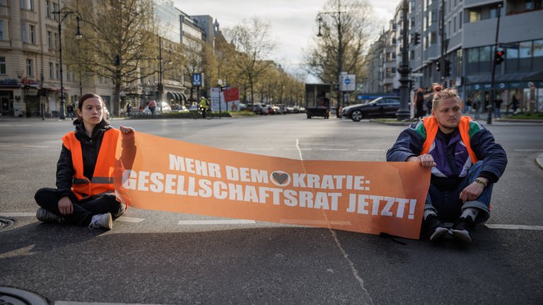 ARD Story: Radikal fürs Klima - Helden oder Kriminelle? Straßenblockade durch Aktivisten der "Letzten Generation" auf dem Kurfürstendamm in Berlin. (Foto: SWR, © SWR/Gordon Welters)
