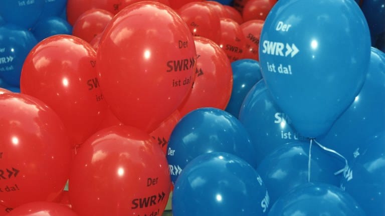 Rote und blaue Ballons tragen den Spruch: "Der SWR ist da!"