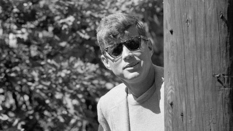 John F. Kennedy lächelt in die Kamera (schwarz-weiß Bild)