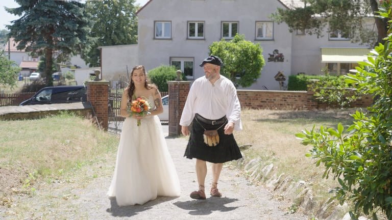 Eine Braut und ihr Vater auf dem Weg zur Kirche