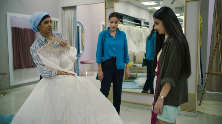 Elaha (Bayan Layla, rechts) ist noch so ganz bereit dafür, sich Hochzeitskleider vorschlagen zu lassen