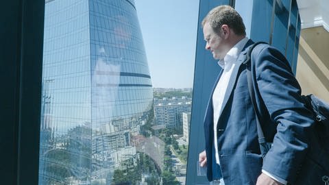 Der Bundestags- und Europaratsabgeordnete Frank Schwabe blickt aus dem Fenster der Flame Towers dem Wahrzeichen der aserbaidschanischen Hauptstadt Baku.
