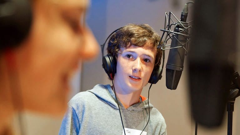 Ein Junge im Studio vor einem Mikrofon