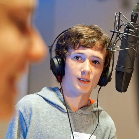 Ein Junge im Studio vor einem Mikrofon