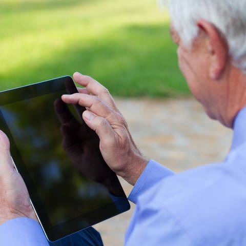 Ein älterer Mann, der über ein Tablet wischt (Foto: Getty Images)