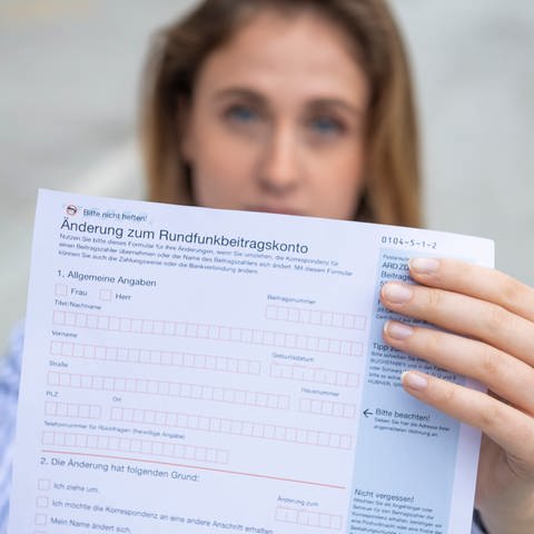 Das bild zeigt eine Frau, die ein Formular zum Rundfunkbeitrag in der Hand hält (Foto: SWR)