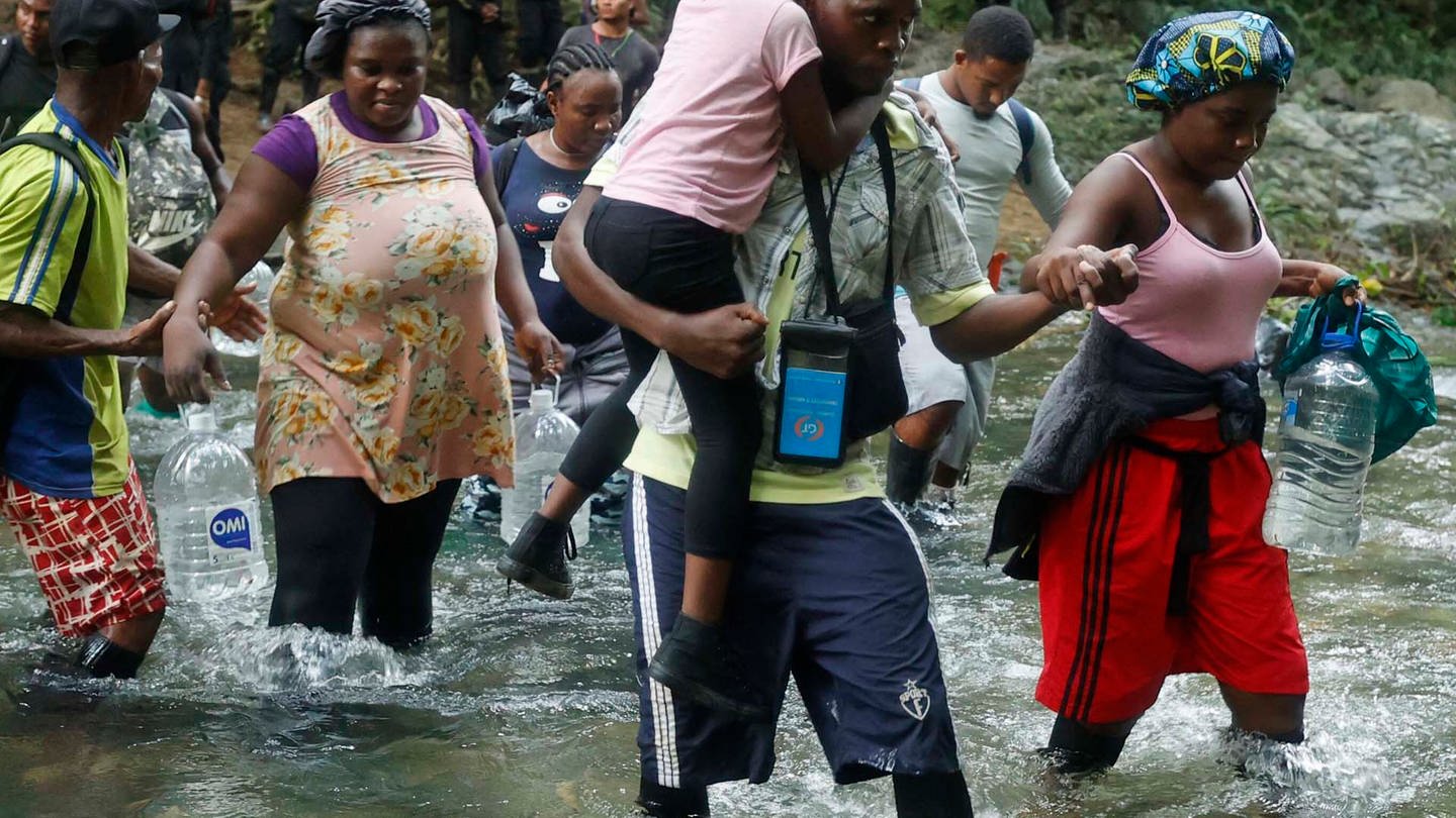 Migrantinnen und Migranten überqueren einen Fluss im Darién-Dschungel (Foto: picture-alliance / Reportdienste, Picture Alliance)