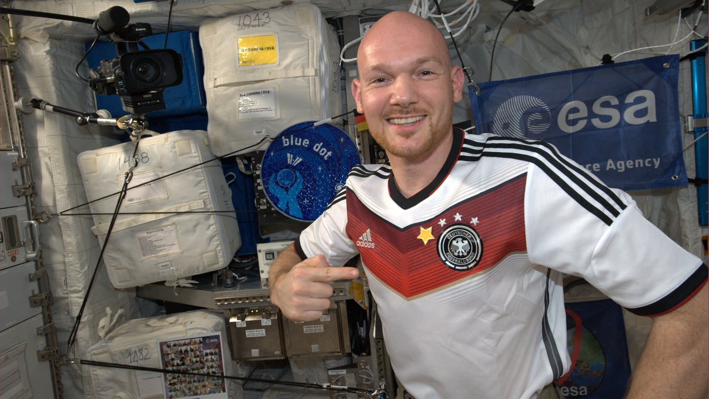 Alexander Gerst im Juli 2014 mit einem T-Shirt der deutschen Fußballnationamannschaft – ergänzt um einen 4. Stern nach der gewonnenen Weltmeisterschaft