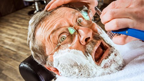 In früheren Zeiten neigten junge Barbiere dazu, alten Kunden Löffel in den Mund zu stecken, wenn deren Wangen schon sehr eingefallen waren. Die Rasur ging dann leichter. Ein unangehemes und übergriffiges Verhalten. (Foto: IMAGO, imago/Panthermedia)