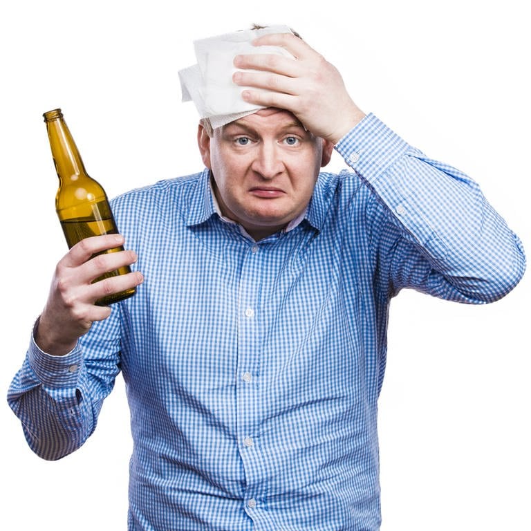 Mann mit Bierflasche in der Hand hat Kopfschmerzen: Ob Bier oder Wein ist egal: Wer einen Kater vermeiden will, muss auf die Menge des Alkohols achten (Foto: Colourbox)