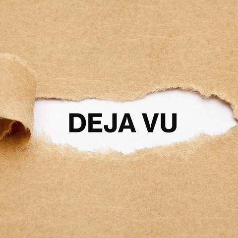 Deja-vu: Schriftzug hinter braunem Packpapier verborgen
