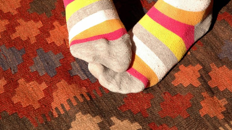 Füße in wärmenden Ringelsocken: Neigen Frauen eher zu kalten Füßen als Männer? (Foto: IMAGO, IMAGO / Steinach)