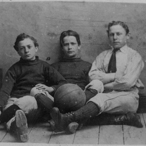 Drei Jungs in Sportkleidung mit Fußball, England um 1885 (Foto: picture-alliance / Reportdienste, picture-alliance / akg-images | akg-images / Archie Miles)