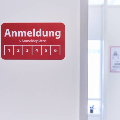 Hinweis-Schild zur Anmeldung im Impfzentrum Augsburg. Bei der Anmeldung werden die Menschen, die geimpft werden sollen u.a. gefragt, ob sie aktuell Fieber haben.  (Foto: IMAGO, IMAGO / reportandum)