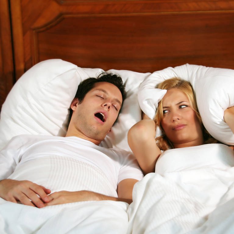 Ein Mann schnarcht, die Frau ist genervt. Schlafapnoe, also Schnachen mit Atemaussetzern, gehört zu den häufigsten Schlafstörungen