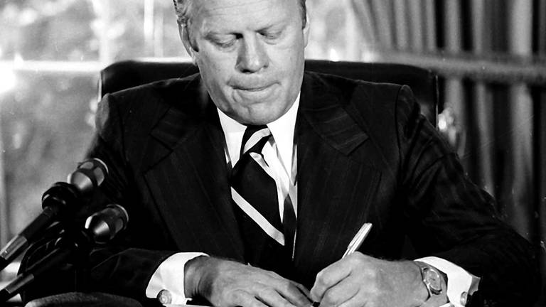 Präsident Gerald Ford unterzeichnet ein Dokument, in dem er dem früheren Präsidenten Richard Nixon "eine vollständige, freie und absolute Begnadigung" für alle "Straftaten gegen die Vereinigten Staaten" während seiner Präsidentschaft gewährt. Ford unterzeichnete das Papier am 8. September 1974 in seinem Büro im Weißen Haus. (Foto: picture-alliance / Reportdienste, picture alliance / ASSOCIATED PRESS)