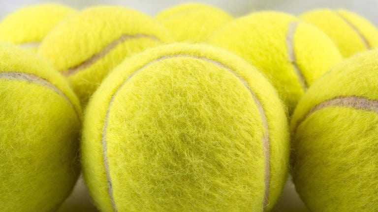 Gelbe Tennisbälle: Der Tennisball ist in seiner heutigen Form 1880 in England entstanden. Damals wurde noch viel auf sandigem Untergrund gespielt und der Filzüberzug schützte das Gummi vor Abrieb. 