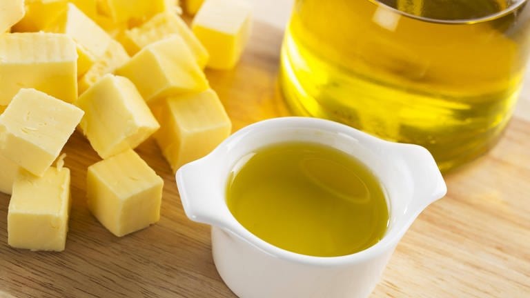 Butterwürfel und eine Flasche mit Olivenöl: Ob Stoffe fest, flüssig oder gasförmig sind, hängt davon ab, wie stark die einzelnen Moleküle sich gegenseitig anziehen – welche Kräfte also zwischen ihnen wirken. 