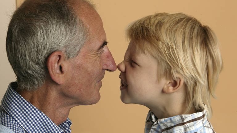 Ein alter Mann und ein Junge stupsen sich mit der Nase an: Alte Menschen riechen anders als junge, denn im Alter verändert sich die Haut. Die Fette, die wir über die Talgdrüsen ausscheiden, verändern sich. Die Haut verliert an Feuchtigkeit und ist daher im Alter trockener. Damit ändert sich auch die Zusammensetzung der Düfte, die unser Körper und unsere Duftzellen abgeben.