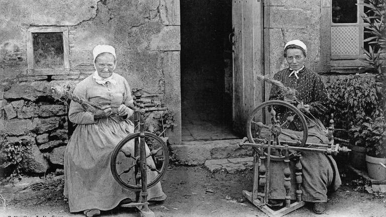 Zwei Frauen mit Spinnrad sitzen vor einem Haus im Burgund  Frankreich (Foto: picture-alliance / Reportdienste, picture alliance / akg-images | akg-images)