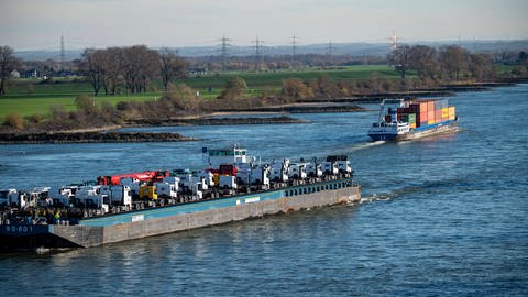 Frachtschiff auf dem Rhein bei Krefeld: Flüsse wie der Rhein fließen auch in der Ebene schnell. Der Grund ist der geringe Reibungswiderstand im Wasser. Und je weiter weg vom Ufer und je tiefer das Flussbett, desto schneller fließt das Wasser.  (Foto: IMAGO, IMAGO / Jochen Tack)