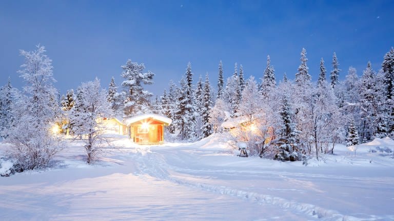 Beleuchtete Hütte in weißer Winterlandschaft: Schnee ist weiß, obwohl Wasser durchsichtig ist (Foto: Colourbox)