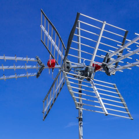 DVB-T-Antenne vor blauem Himmel: Beim Fernsehen können Zeitverzögerungen von 5 Sekunden oder noch länger auftreten, besonders über DVB-T – also der digitalen terrestrischen Verbreitung. (Foto: IMAGO, IMAGO / YAY Images)