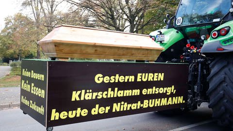 Traktor mit einem echten Sarg und dem Banner: Gestern euren Klaerschlamm entsorgt, heute der Nitrat-Buhmann - Buhmann ist das älteste Wort für den Bauern (Foto: IMAGO, IMAGO / Joachim Sielski)