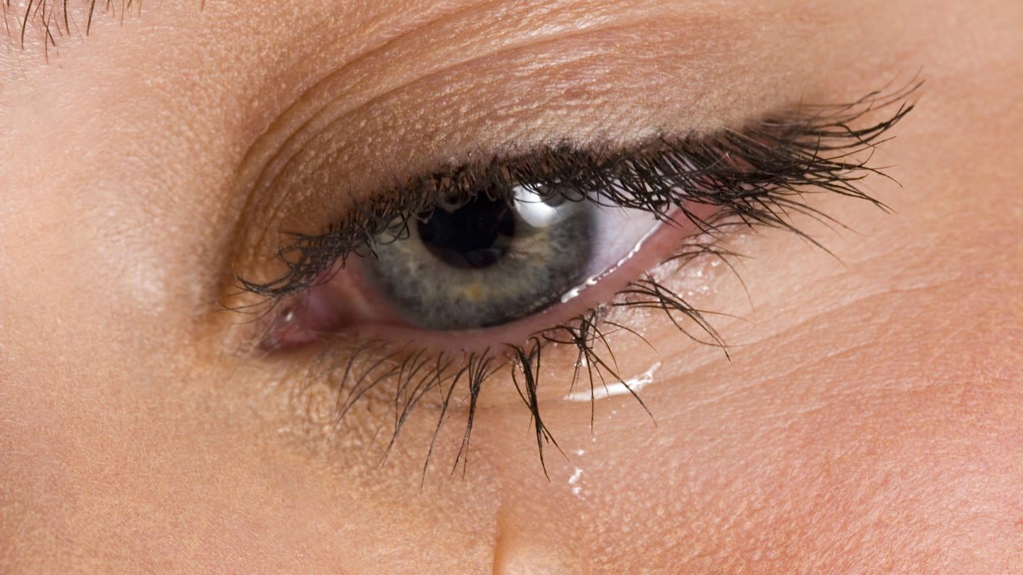 Nahafnahme vom Auge einer weinenden Frau: Tränen haben eine Salzkonzentration von etwas unter einem Prozent; sie enthalten somit etwa genau so viel Salz wie das Blut.