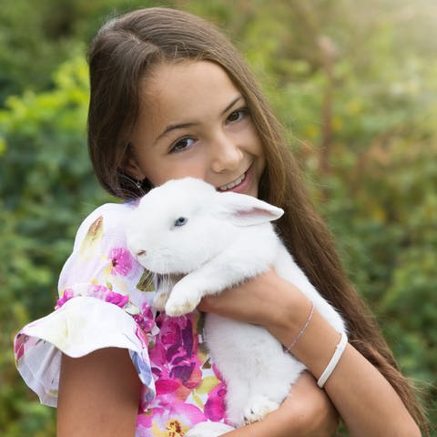 IMAGO  Panthermedia (Foto: IMAGO, Ein Mädchen hält ein weißes Kaninchen auf dem Arm)